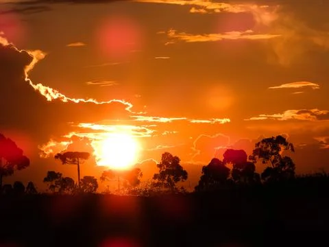 Orange sun setting in the mountains Stock Photos