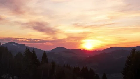 Orange sun setting over the forest landscape. The sun setting behind the clouds Видео 186492353
