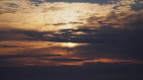 The orange sun shines behind dramatic clouds Stock Footage 107070923