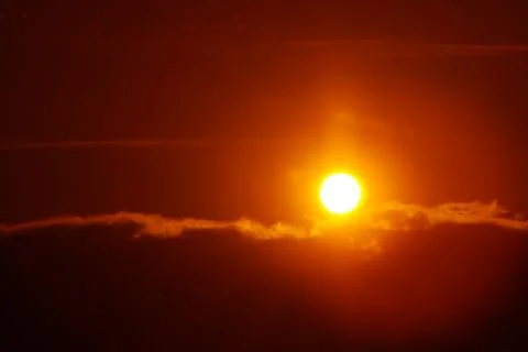 Orange sun in the sky in the clouds Stock Photos