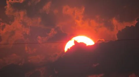 Orange sun through clouds Stock Photos