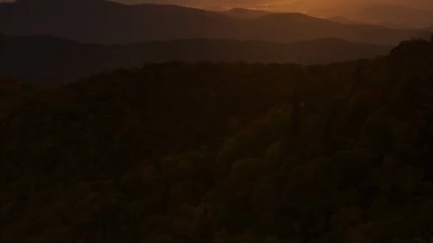 Orange sunlight falling on the mountain ranges at sunset Stock Footage 103401925