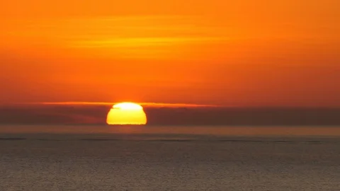 Orange sunrise over ocean horizon, peaceful seascape of dawn skies above Stock Footage