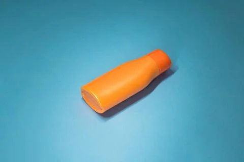 Orange Sunscreen Bottle On Blue Background With Copy Space Flat Lay Stock Photos