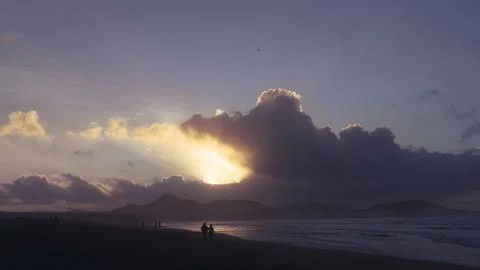 Orange sunset and dramatic clouds on the ocean shore Foto stock