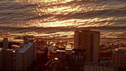 Orange Sunset beams on sea & shoreline Seapoint Cape Town Stock Footage