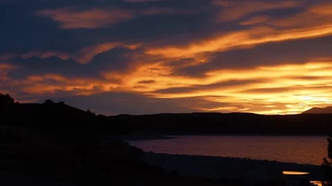 Orange sunset clouds sweep across lake sky Stock Footage 140612068