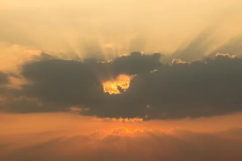 Orange sunset in the evening with a cloud with a central hole like the eye of Stock Photos