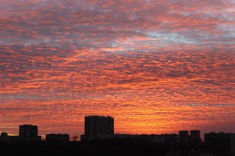 An orange sunset that illuminates the clouds flying by over the already night-ti Foto stock