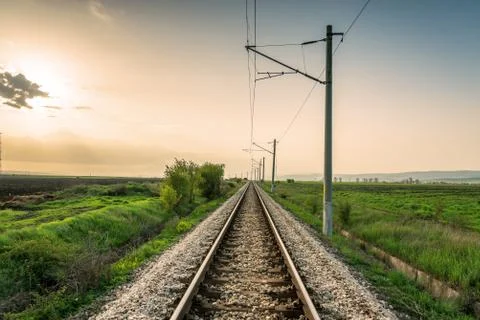 Orange sunset in low clouds over railroad. Stock Photos