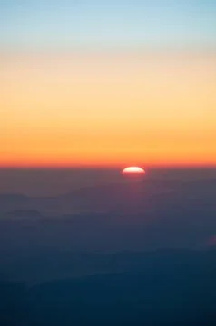 Orange sunset in the mountains. View from a height. Stock Photos
