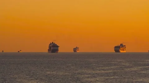 Orange sunset in ocean. Rays of setting sun illuminate hulls of ships on horizon Stock-Footage 222409588