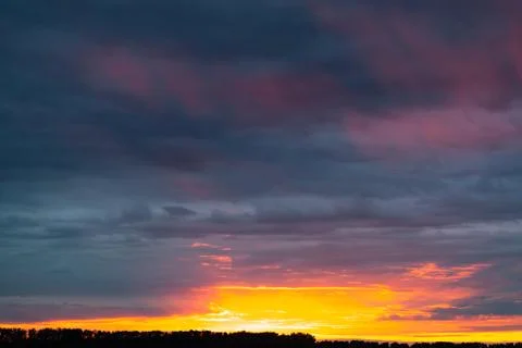 Orange sunset over grey cloudy sky Stock Photos