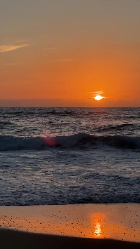Orange sunset over ocean waves crashing on beach in Portugal Stock Footage 346582489