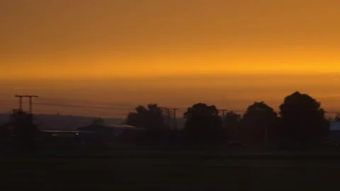 Orange sunset over rural fields and trees 스톡 동영상 336818561