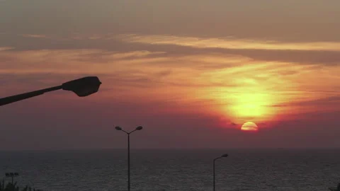 Orange sunset over the sea. View from the house, with lampposts. Stock Footage 155692397