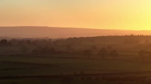 Orange sunset over silhoutted undulating wooded landcape, parallax pan Stock-Footage 262580376