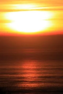 The orange sunset reflected in the small waves. Foto stock