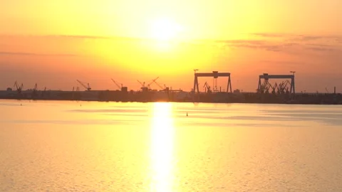 Orange sunset on river overlooking city port. Stockbeeldmateriaal 155863376