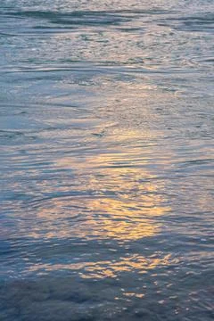 Orange sunset on the sea, the setting sun is reflected in the water. Stock Photos