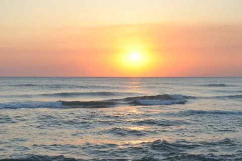 Orange sunset on the sea waves Stock Photos