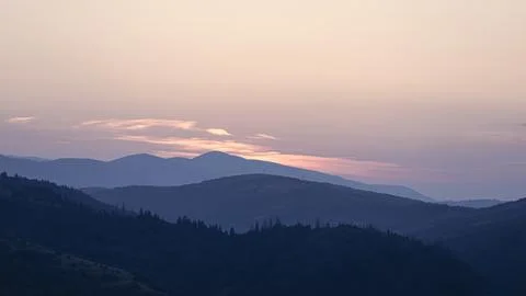 Orange sunset with the setting sun behind the mountains Stock Photos