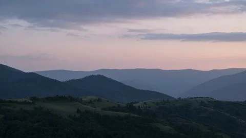 Orange sunset with the setting sun behind the mountains Stock Photos