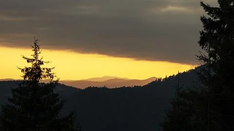 Orange sunset with the setting sun behind the mountains Stock Photos