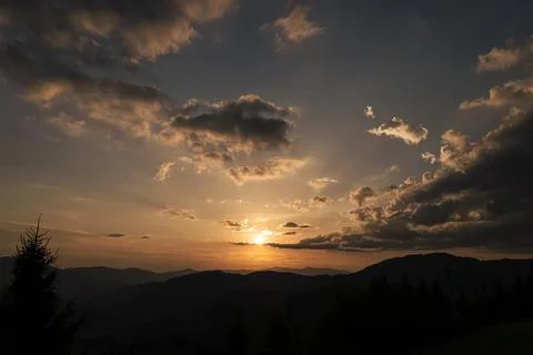 Orange sunset with the setting sun behind the mountains Fotos Stock