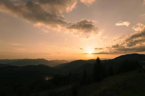 Orange sunset with the setting sun behind the mountains Stock Photos