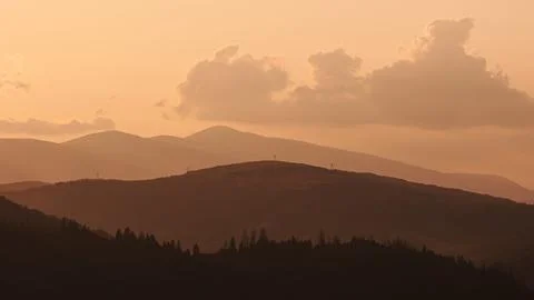 Orange sunset with the setting sun behind the mountains Stock Photos