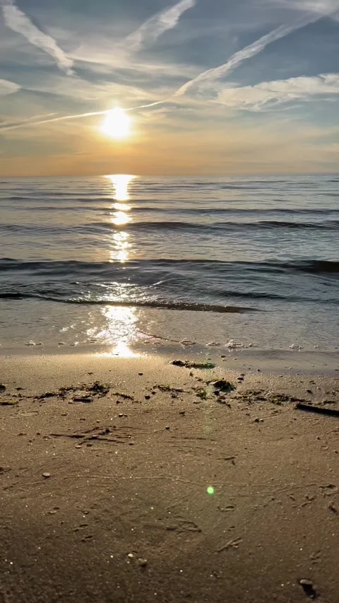 Orange sunset sky with clouds against the backdrop of ocean waves and the coast. Stock Footage 280237930