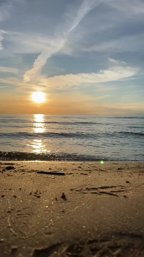 Orange sunset sky with clouds against the backdrop of ocean waves and the coast. Stock-Footage 280237986