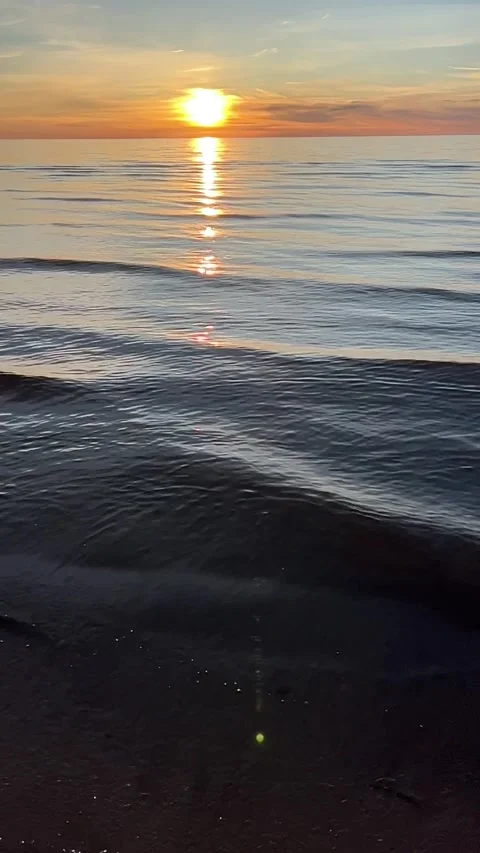 Orange sunset sky with clouds against the backdrop of ocean waves and the coast. Stock Footage 280237990