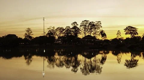 Orange sunset sky with shadow of tree over river, Silhouette sky clouds backg Stock Photos