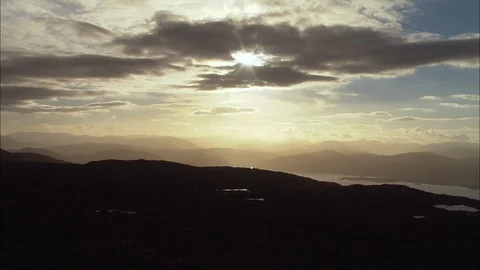 Orange sunset sky with sun rays and clouds, Sunrise Over The Grampians And Loch Stock Footage 108597318