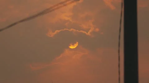 Orange Sunset Sun Peeking Through Clouds with Cable Silhouette Stock Footage 281150869