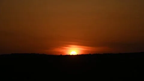Orange sunset time lapse with sun and backlit clouds Stock Footage 251570068