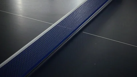 Orange table tennis ball hit the net on the indoor blue table in slow motion  Stock Footage