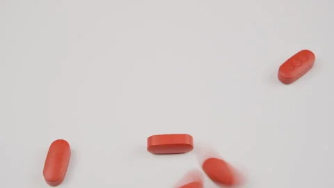 Orange tablets fall out of the bottle onto the table, slow motion. Antiviral dru Stock Footage 278050810