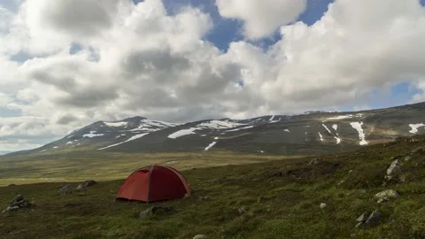 Orange tent on a meadow in front of a mountain range,4k,timelapse Stock Footage 230124557