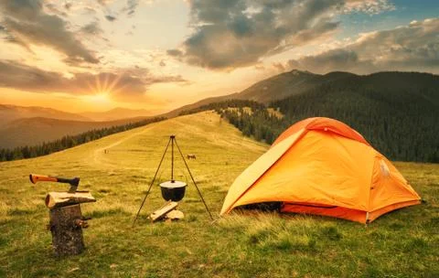 Orange tent with a prepared bonfire at sunset Stock Photos