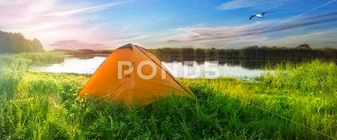 Orange tent on the shore of the lake Stock Photos