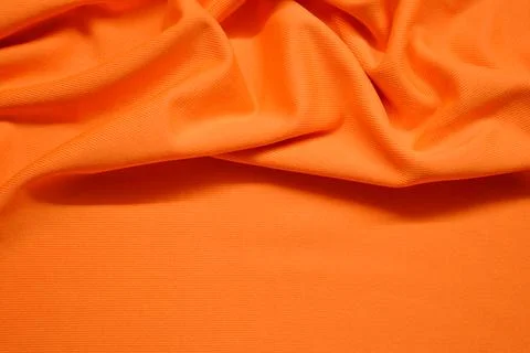 Orange textile pattern as a background. Orange material texture on fabric Stock Photos