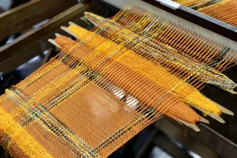 Orange thread in the weaving machine Stock Photos