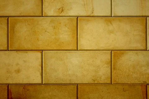 Orange tiles with horizontal rows of brownish rectangles on the wall Stock Photos