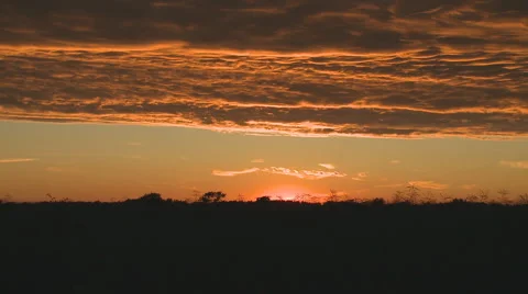 Orange tipped clouds over field Vídeo Stock 3879751