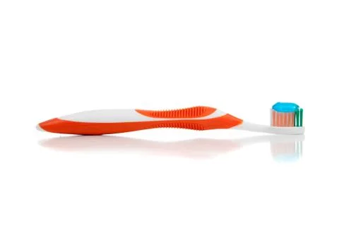An orange toothbrush with paste on white Stock Photos