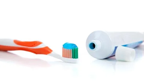 Orange toothbrush with toothpaste on a white background Stock Photos
