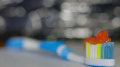 Orange toothpaste on a toothbrush Stock Footage 82533587